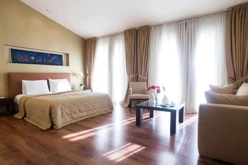 Une chambre lumineuse avec un grand lit et un coin salon.
