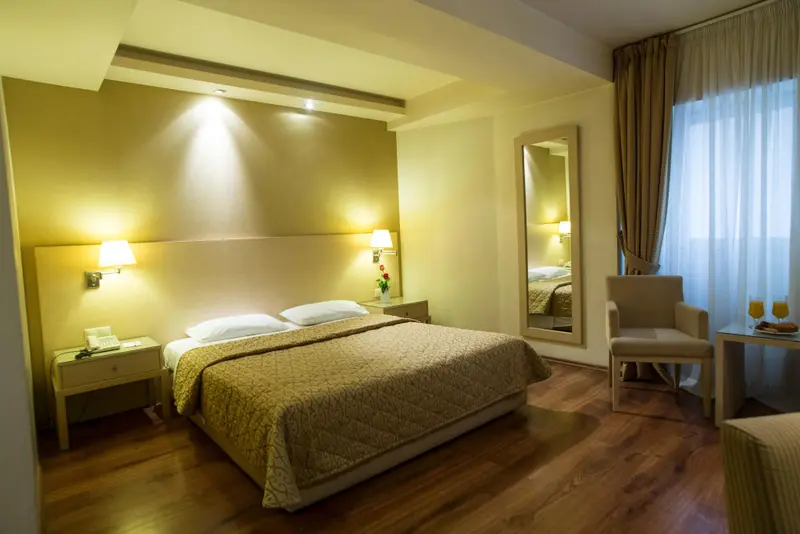 Une chambre lumineuse avec un grand lit et un fauteuil.