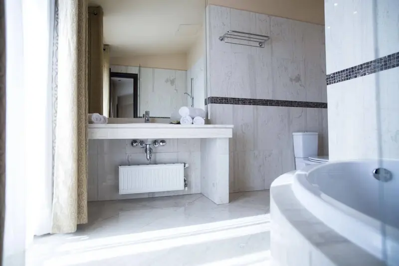 Une salle de bain lumineuse avec baignoire et vasque.