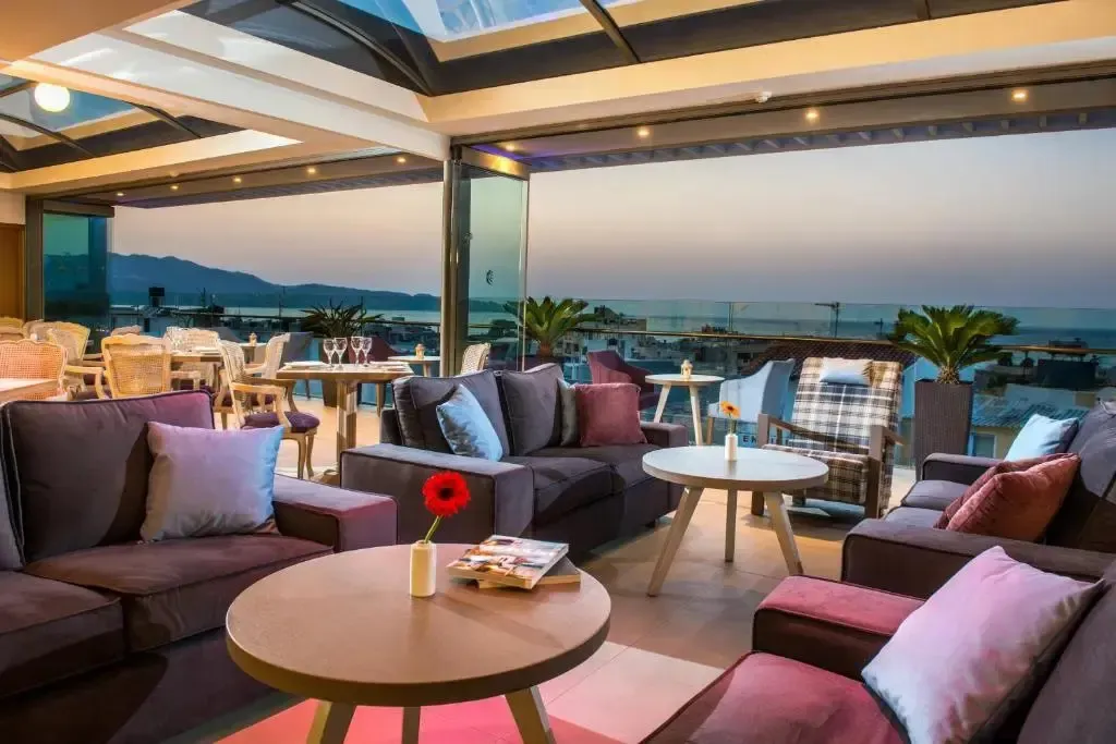 Espace de détente extérieur avec canapés et tables basses face à la mer.