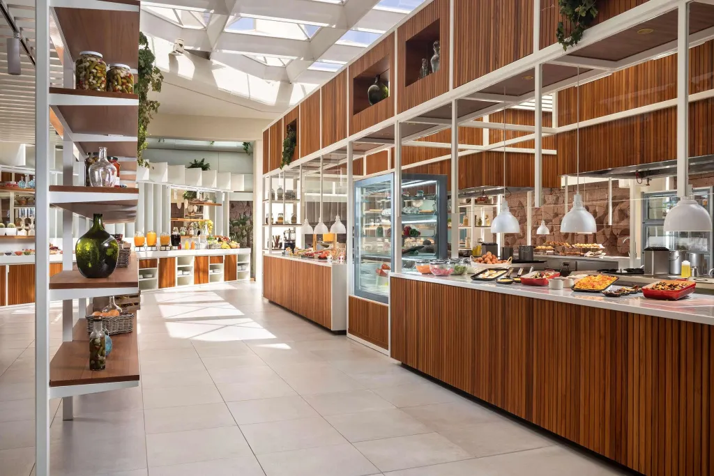 Un buffet propose une variété de plats et de boissons dans une salle lumineuse.