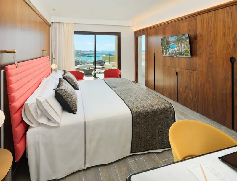 Une chambre lumineuse avec un grand lit et une vue sur la mer.