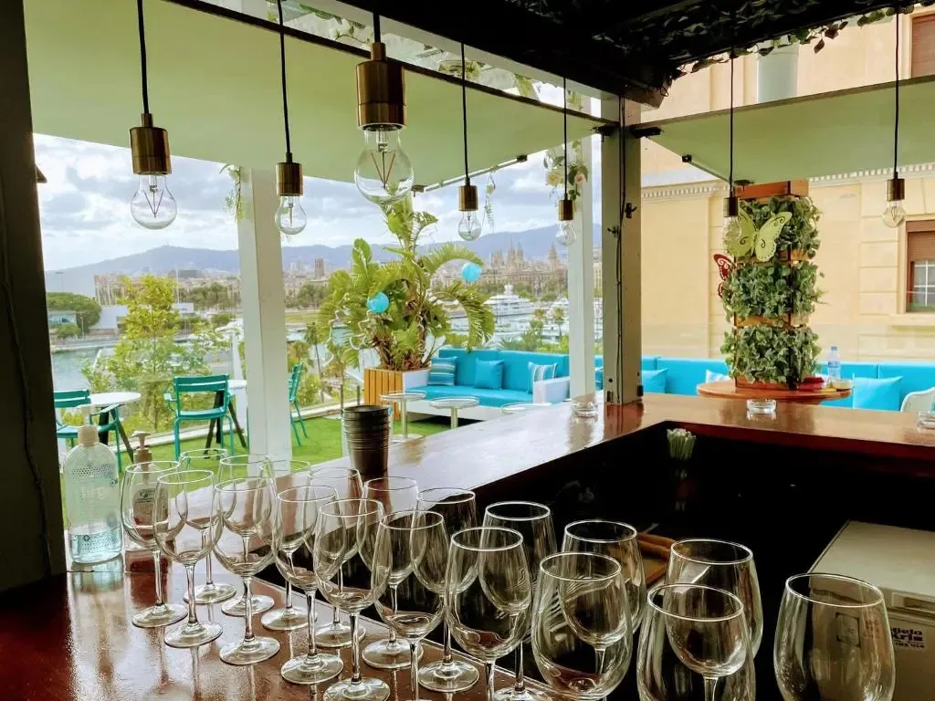 Un comptoir de bar avec des verres, donnant sur une vue urbaine et maritime.