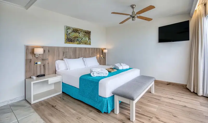 Une chambre lumineuse avec un grand lit et une décoration sobre.