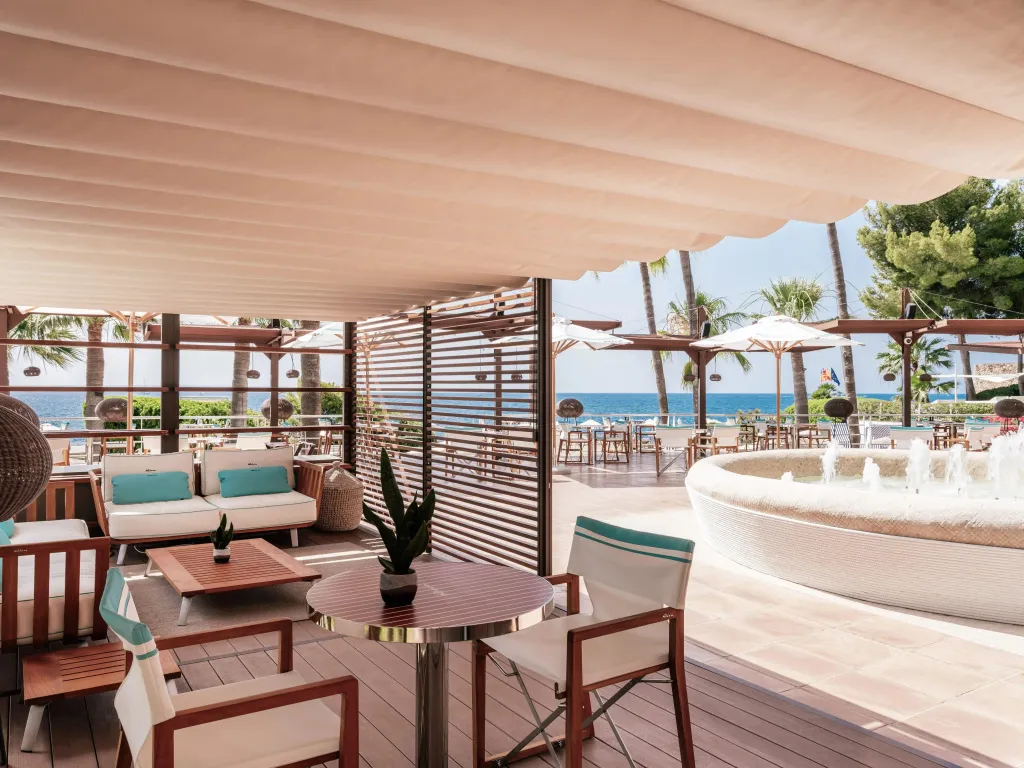 Espace de détente extérieur avec mobilier confortable et vue sur la mer.