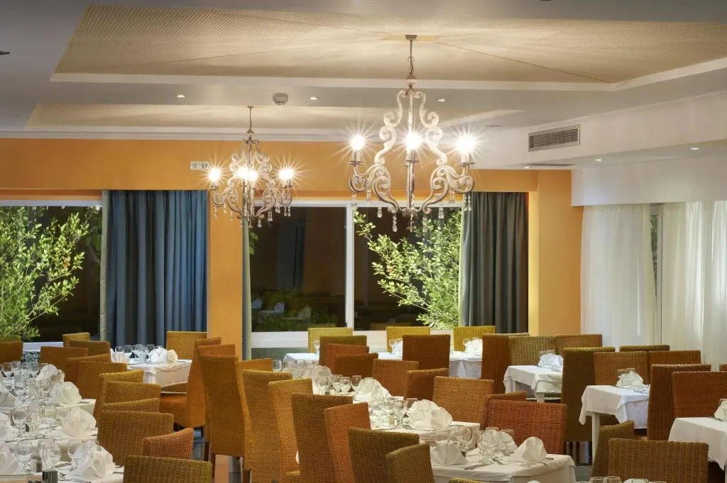 Une salle lumineuse avec des tables dressées pour un repas.