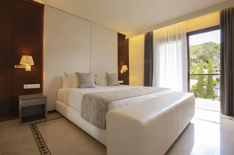 Une chambre lumineuse avec un grand lit et un accès à une terrasse.