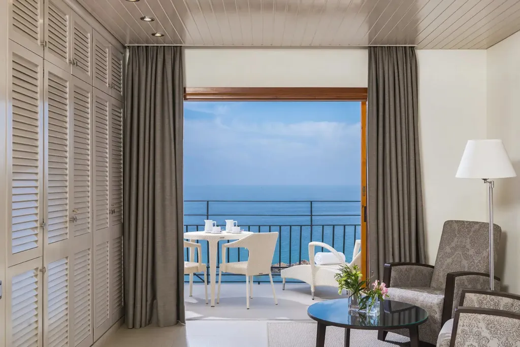 Une pièce lumineuse s'ouvre sur une terrasse avec vue sur la mer.