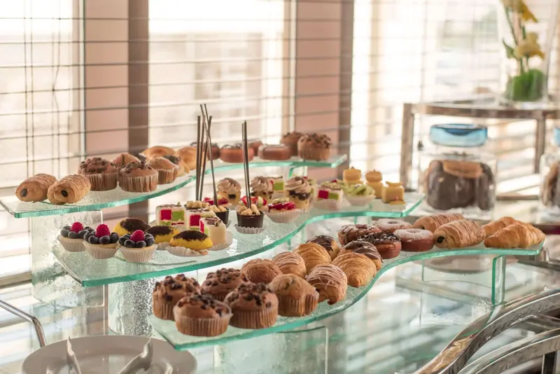 Présentation de pâtisseries variées sur un présentoir en verre.