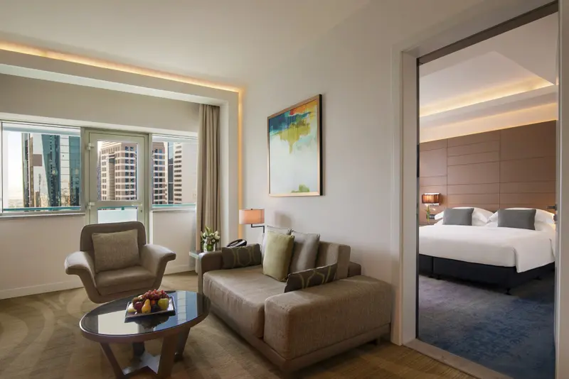 Un salon lumineux s'ouvre sur une chambre à coucher.