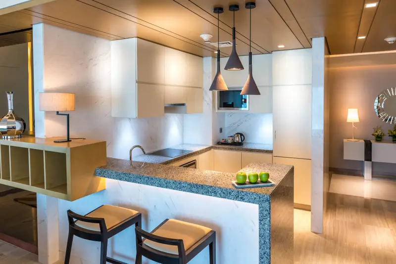 Une cuisine moderne avec un îlot central et des tabourets.