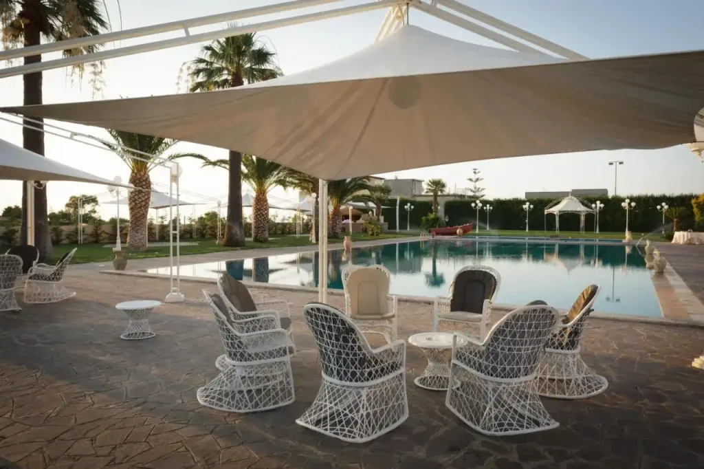 Espace de détente extérieur avec mobilier de jardin près d'une piscine.