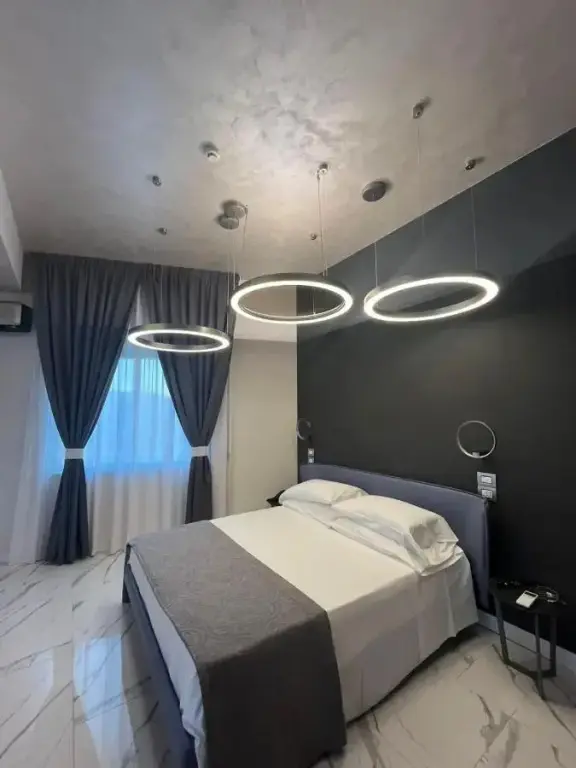 Une chambre moderne avec un grand lit recouvert d'une courtepointe blanche et grise.