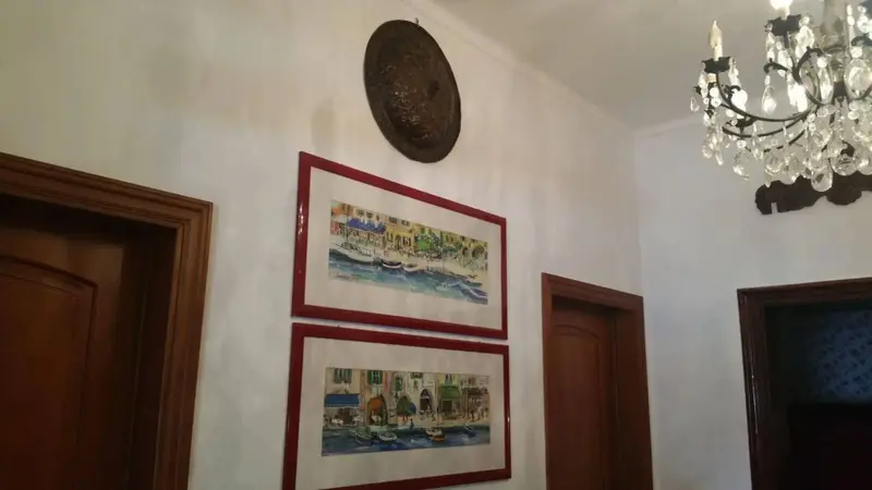 Décoration murale dans un couloir éclairé par un lustre.