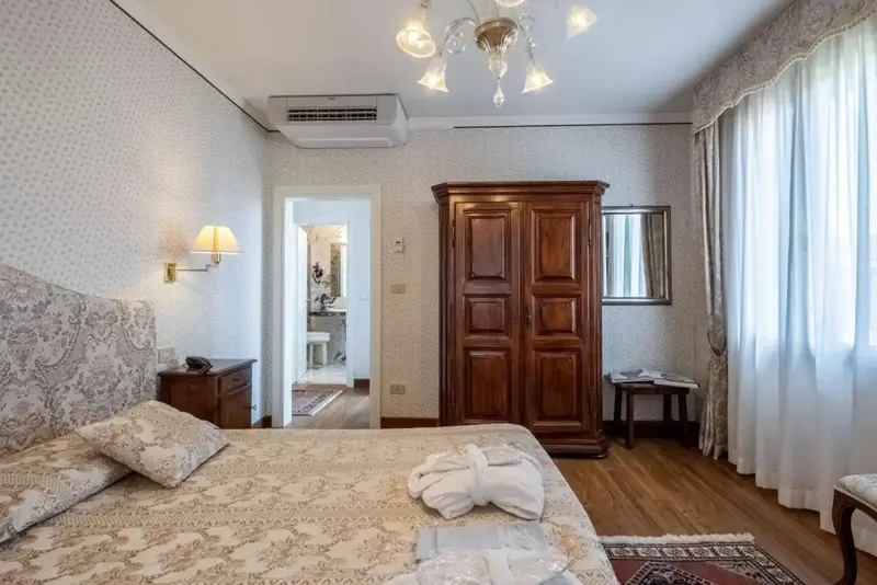 Une chambre lumineuse avec un grand lit et un meuble en bois.
