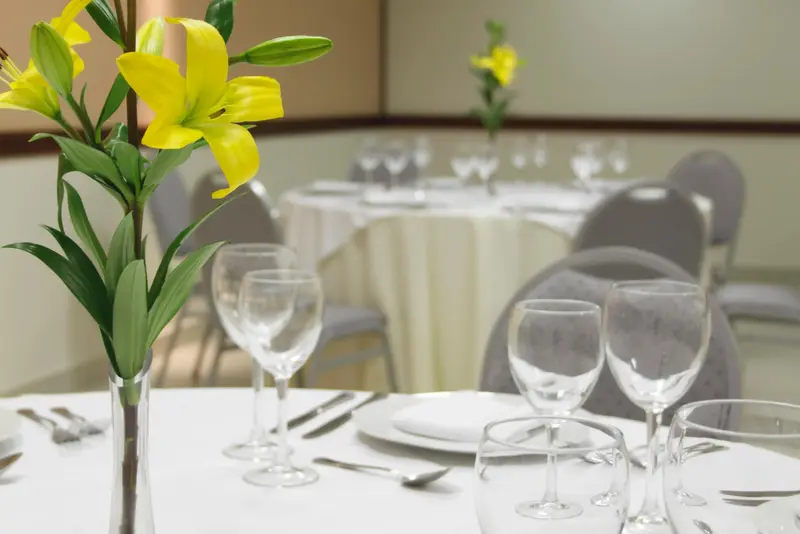 Une table dressée avec des couverts et un bouquet de fleurs.