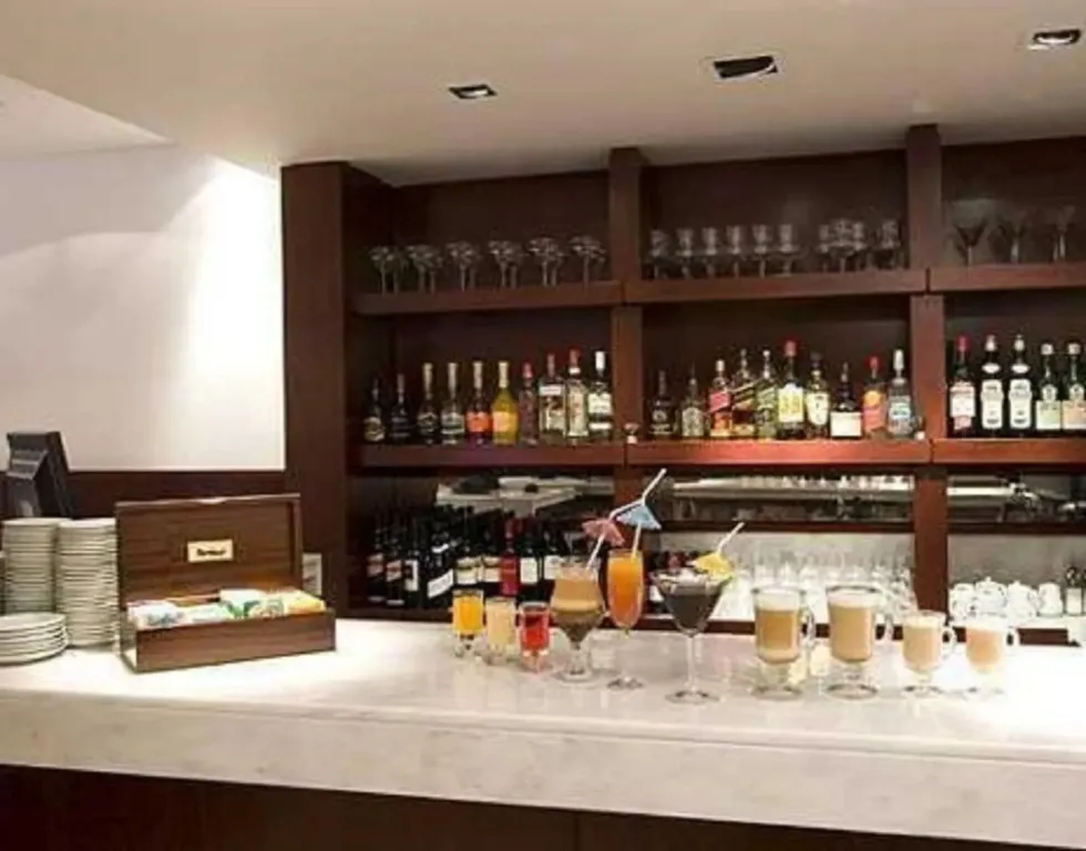 Un comptoir de bar présente une variété de boissons colorées et de verres.