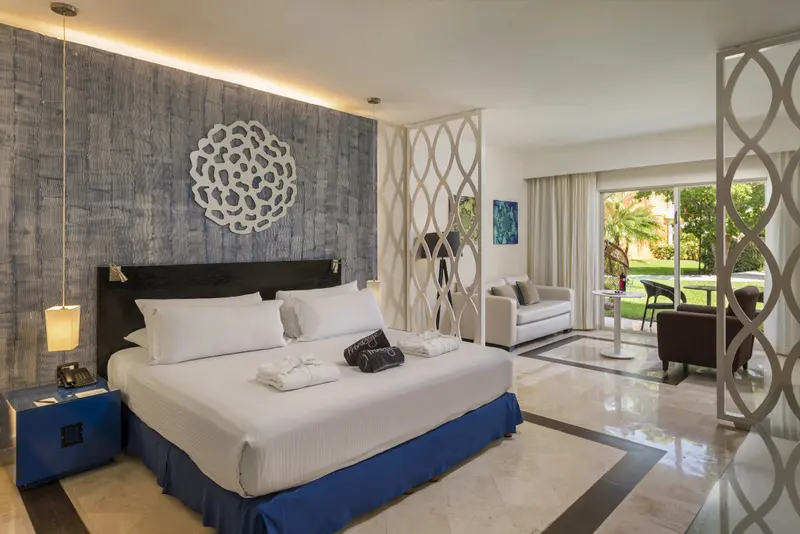 Une chambre lumineuse avec un grand lit et un espace détente.