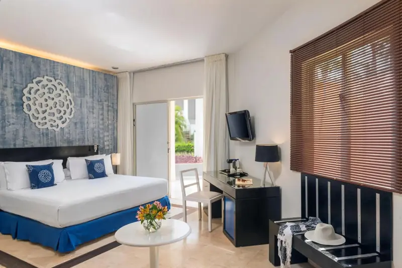 Une chambre lumineuse avec un grand lit et un bureau.