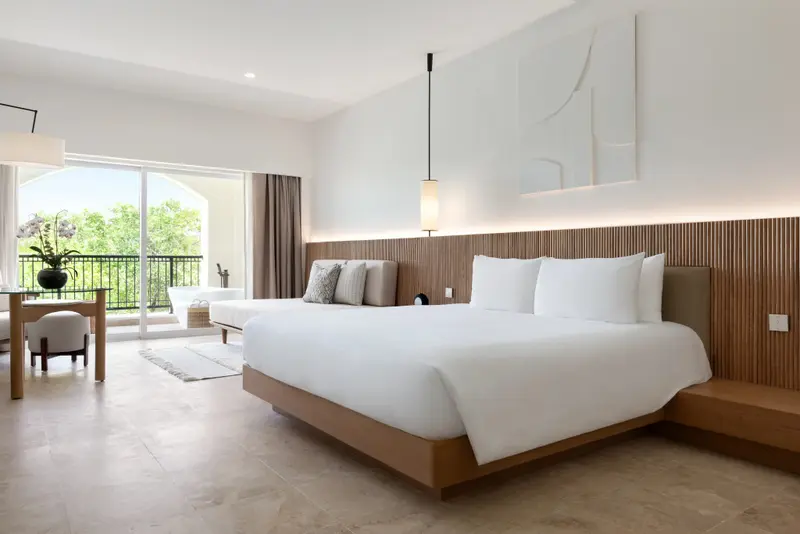 Une chambre lumineuse avec un grand lit et un espace détente.