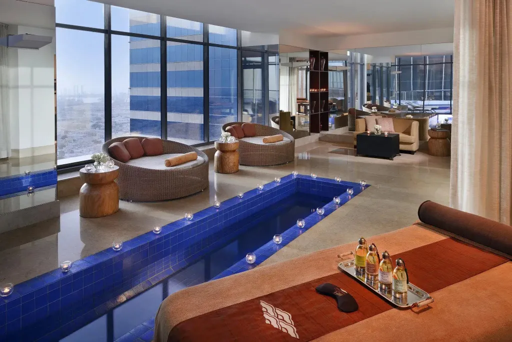 Espace de détente intérieur avec piscine et mobilier confortable.