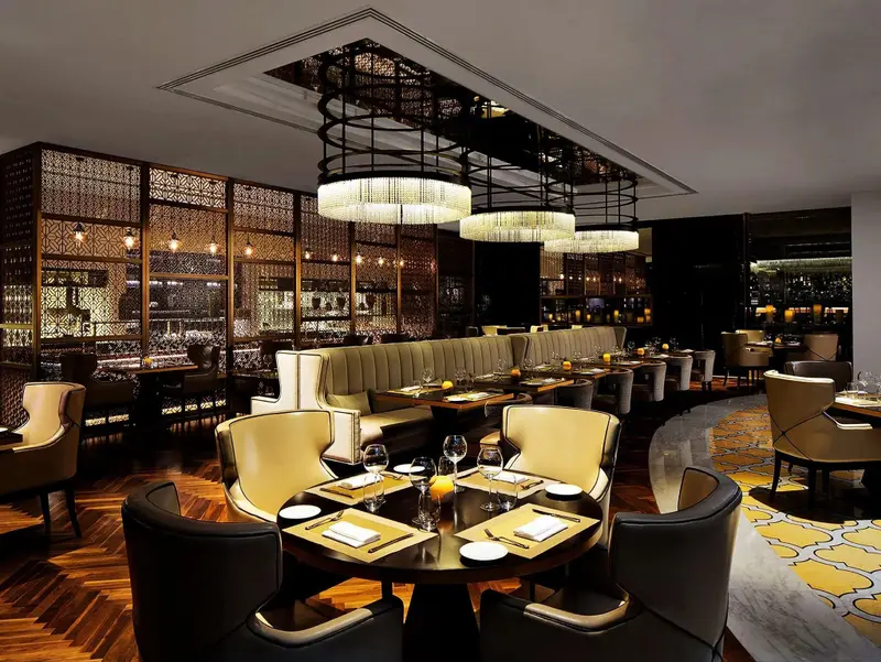Une salle de restaurant élégante avec des tables dressées et un éclairage sophistiqué.