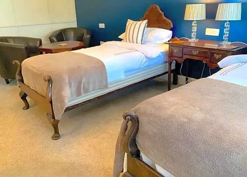 Une chambre avec deux lits simples et des meubles en bois.