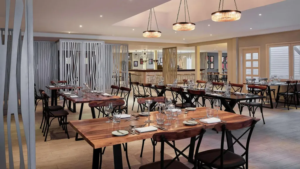 Une salle lumineuse avec des tables dressées pour le repas.