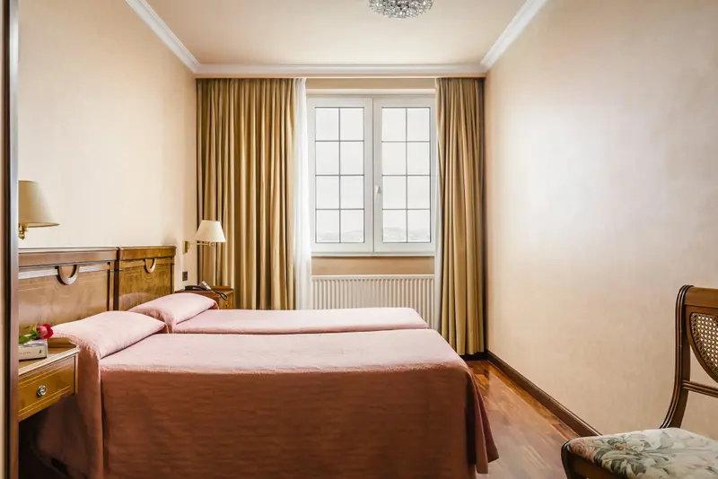 Une chambre lumineuse avec un lit double et une fenêtre.