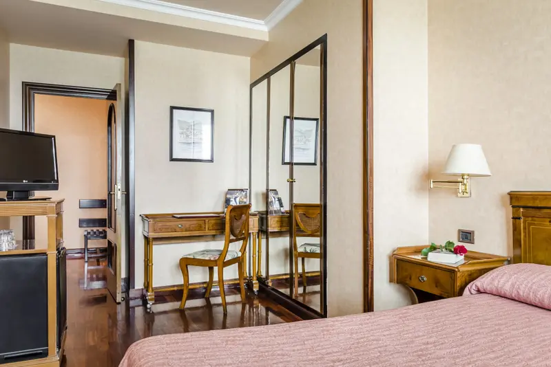 Une chambre à coucher lumineuse avec un bureau et un lit recouvert d'une courtepointe.