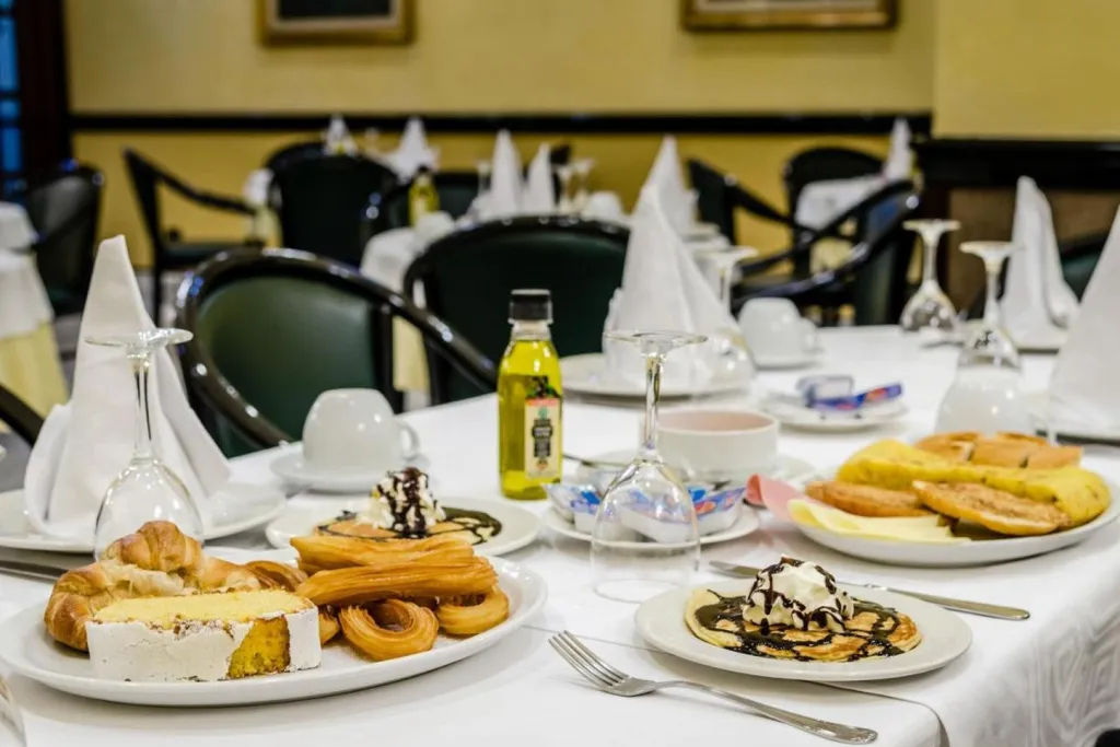 Une table dressée avec des pâtisseries et des boissons dans une salle lumineuse.