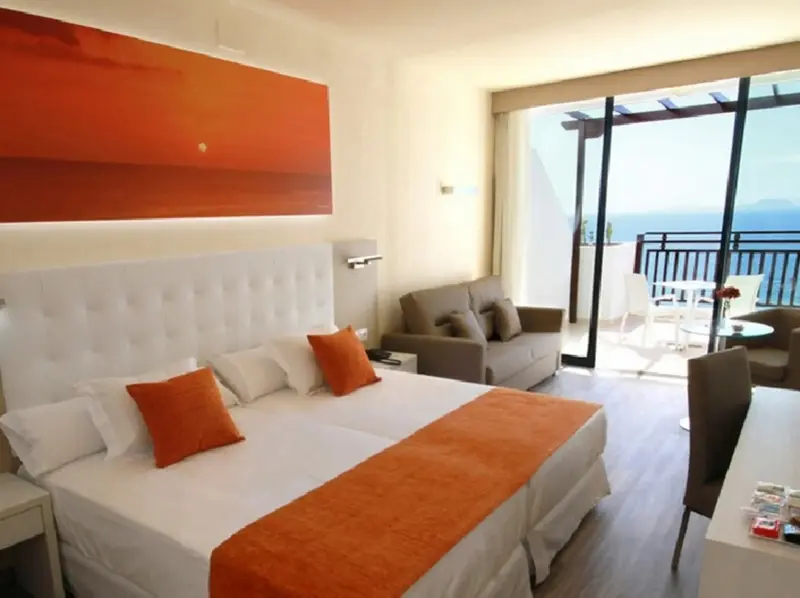 Une chambre lumineuse avec un grand lit et un accès à une terrasse.