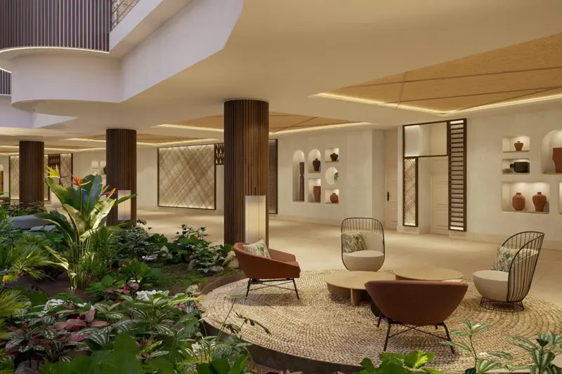 Espace de détente intérieur avec mobilier design et plantes tropicales.