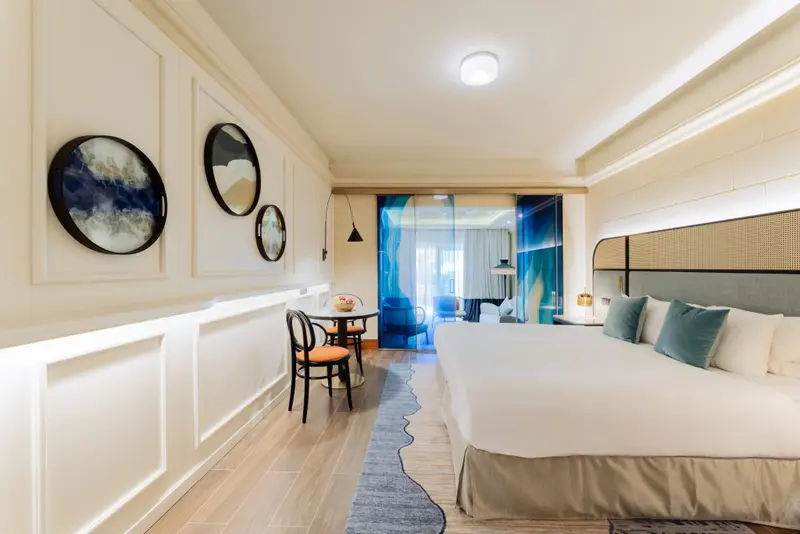 Une chambre lumineuse avec un lit double et un coin repas.