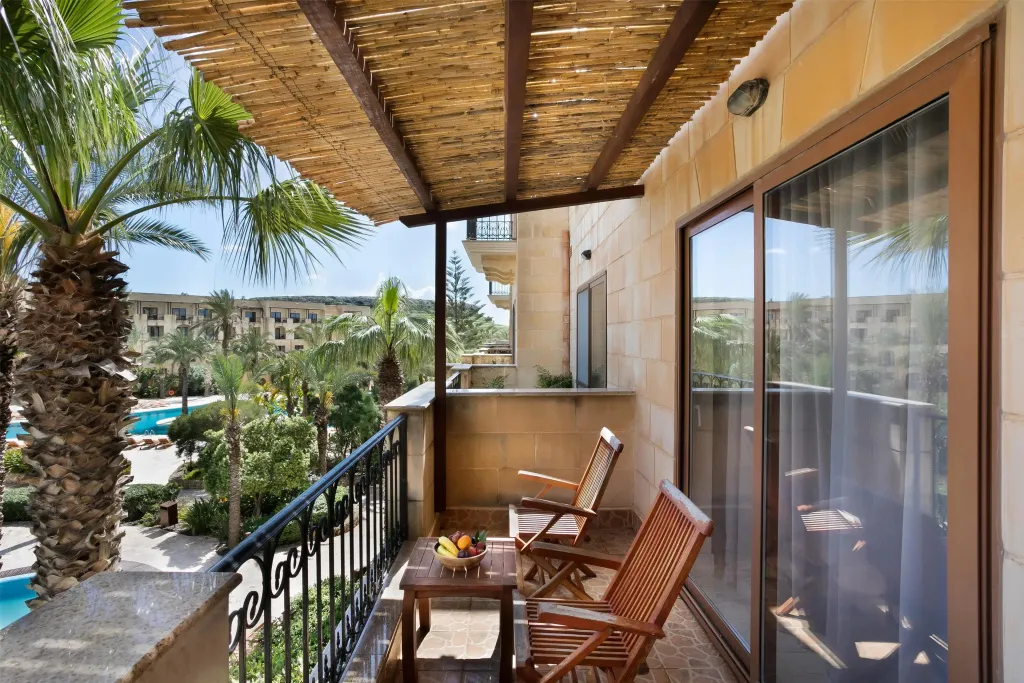 Une terrasse ombragée offre une vue sur une piscine et la végétation luxuriante.
