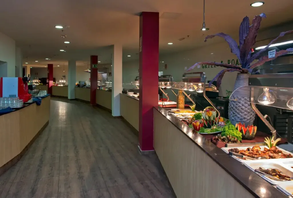 Un long buffet propose une variété de plats décorés et colorés.