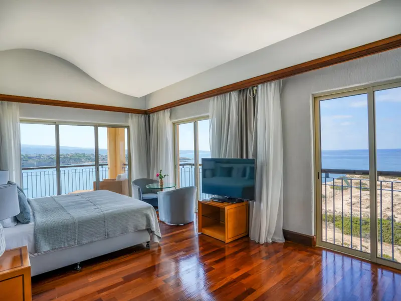 Une chambre lumineuse avec un grand lit et une vue sur la mer.