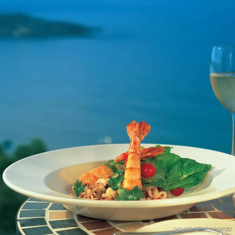 Assiette de salade de fruits de mer avec une vue sur la mer.