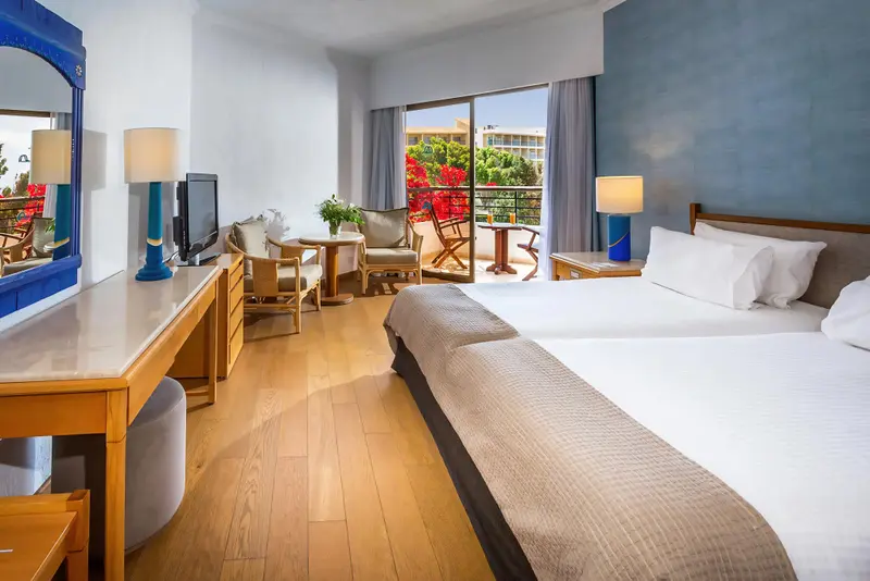 Une chambre lumineuse avec un lit double et un espace détente.
