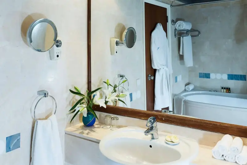 Une salle de bain lumineuse avec une baignoire et des serviettes blanches.
