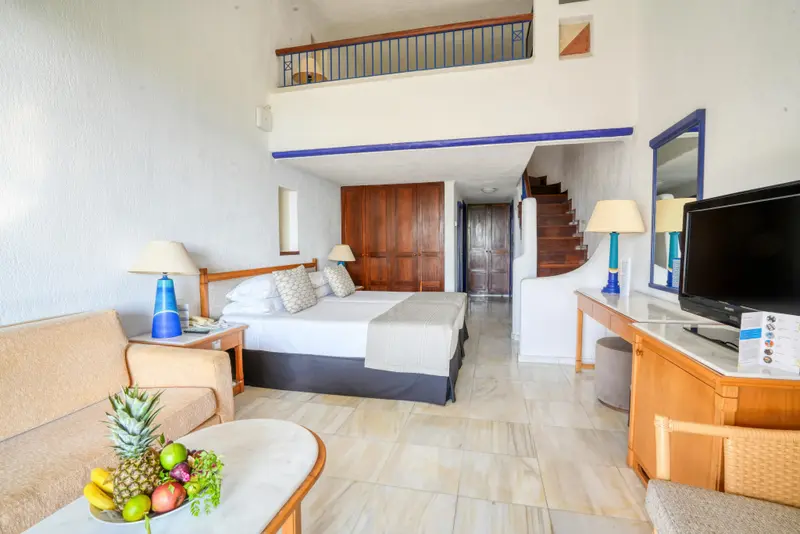 Une chambre lumineuse avec un lit double et un espace salon.