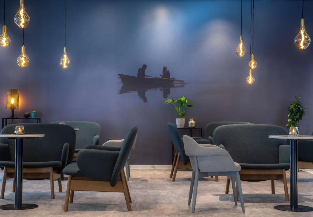 Espace de détente avec des fauteuils et des suspensions lumineuses.