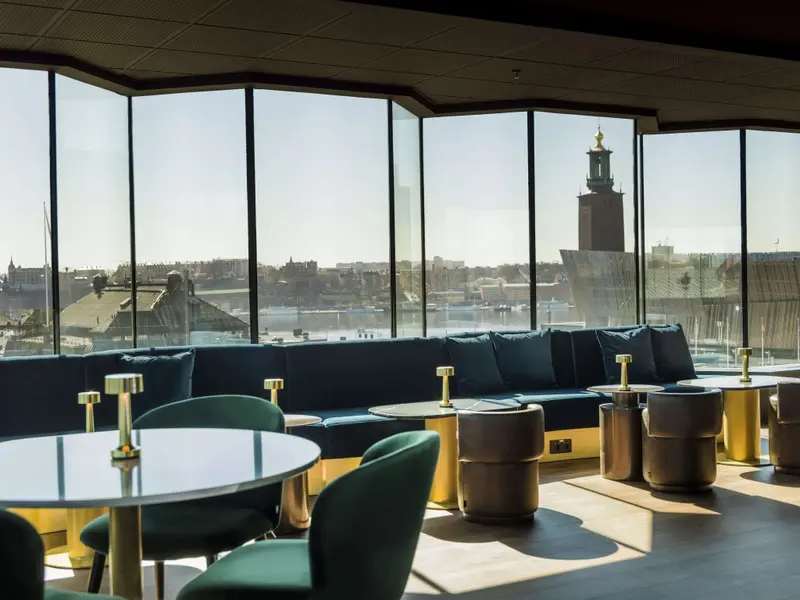 Espace de détente intérieur avec mobilier design et vue sur la ville.