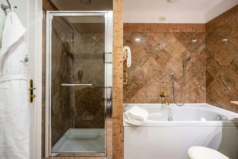 Une salle de bain avec douche et baignoire en marbre.