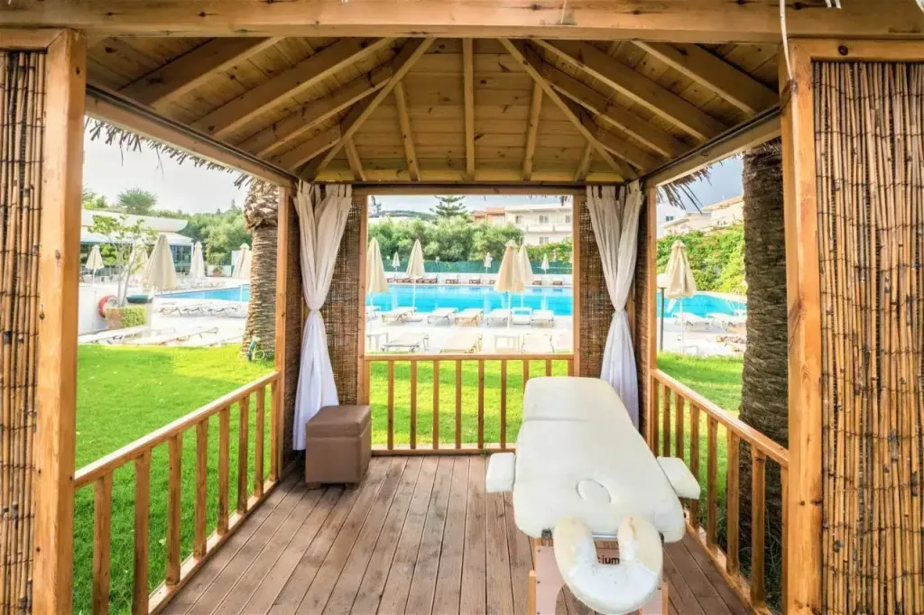 Un espace de détente extérieur avec une table de massage et vue sur une piscine.