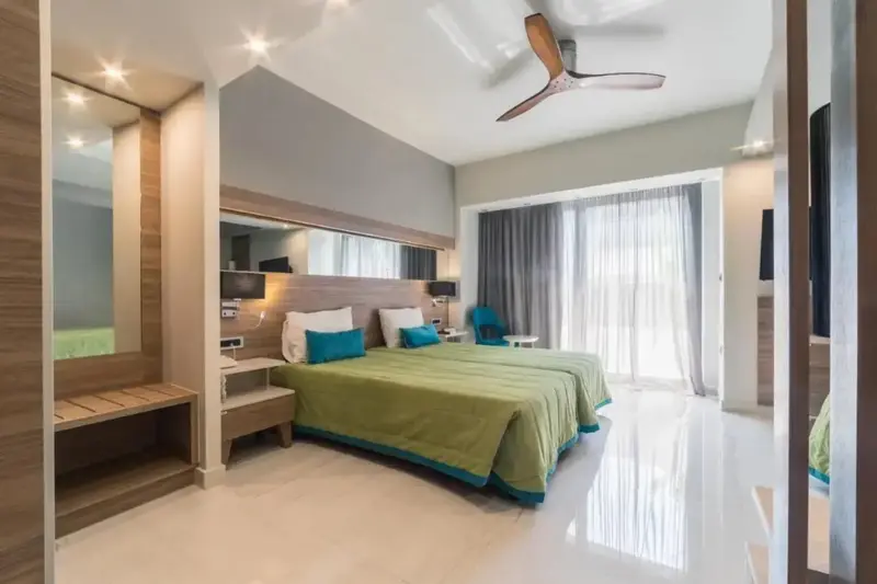 Une chambre lumineuse avec deux lits simples et un accès à une terrasse.