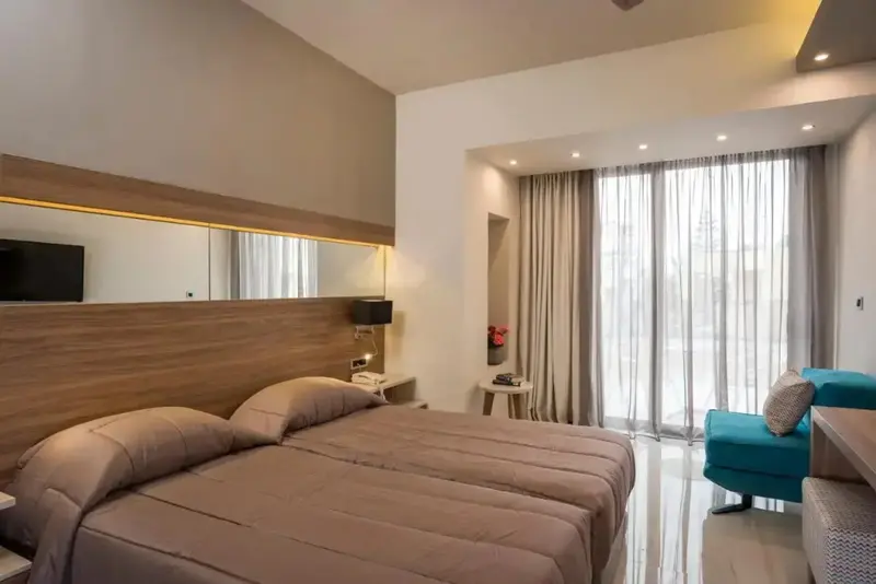 Une chambre lumineuse avec un grand lit et un coin salon.