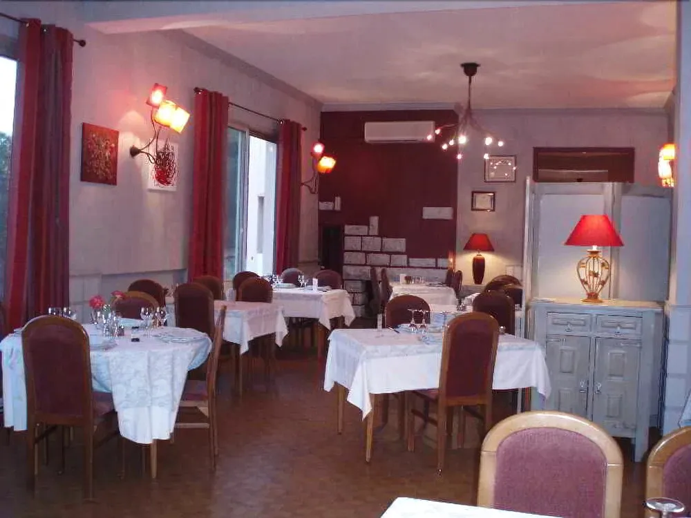Une salle de restaurant avec des tables nappées et des chaises confortables.