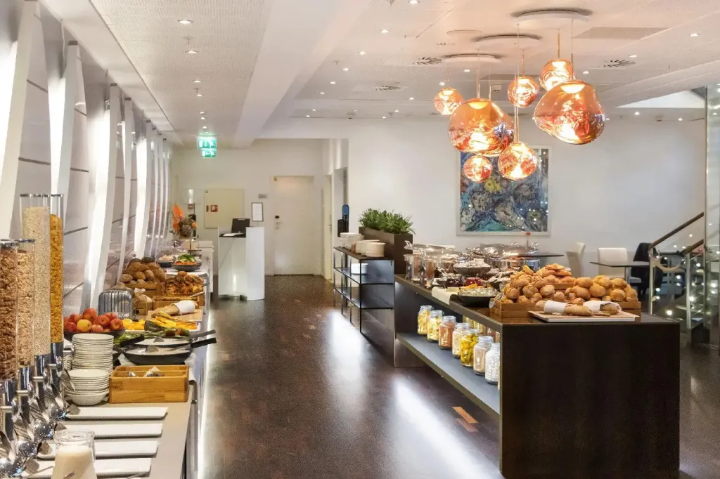 Un buffet propose une variété de plats et de boissons dans une salle lumineuse.