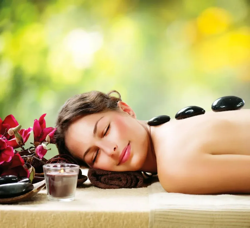 Une femme se détend sur une table de massage en extérieur.